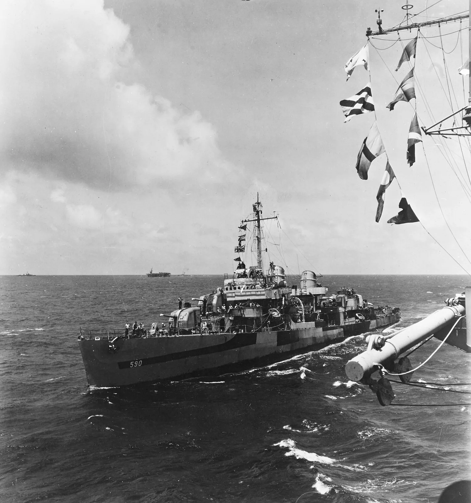 USS Paul Hamilton (DD-590) comes alongside the escort carrier USS Makin Island (CVE-93) during the Iwo Jima campaign, 11 March 1945. She is wearing Camouflage Measure 32, Design 3d.