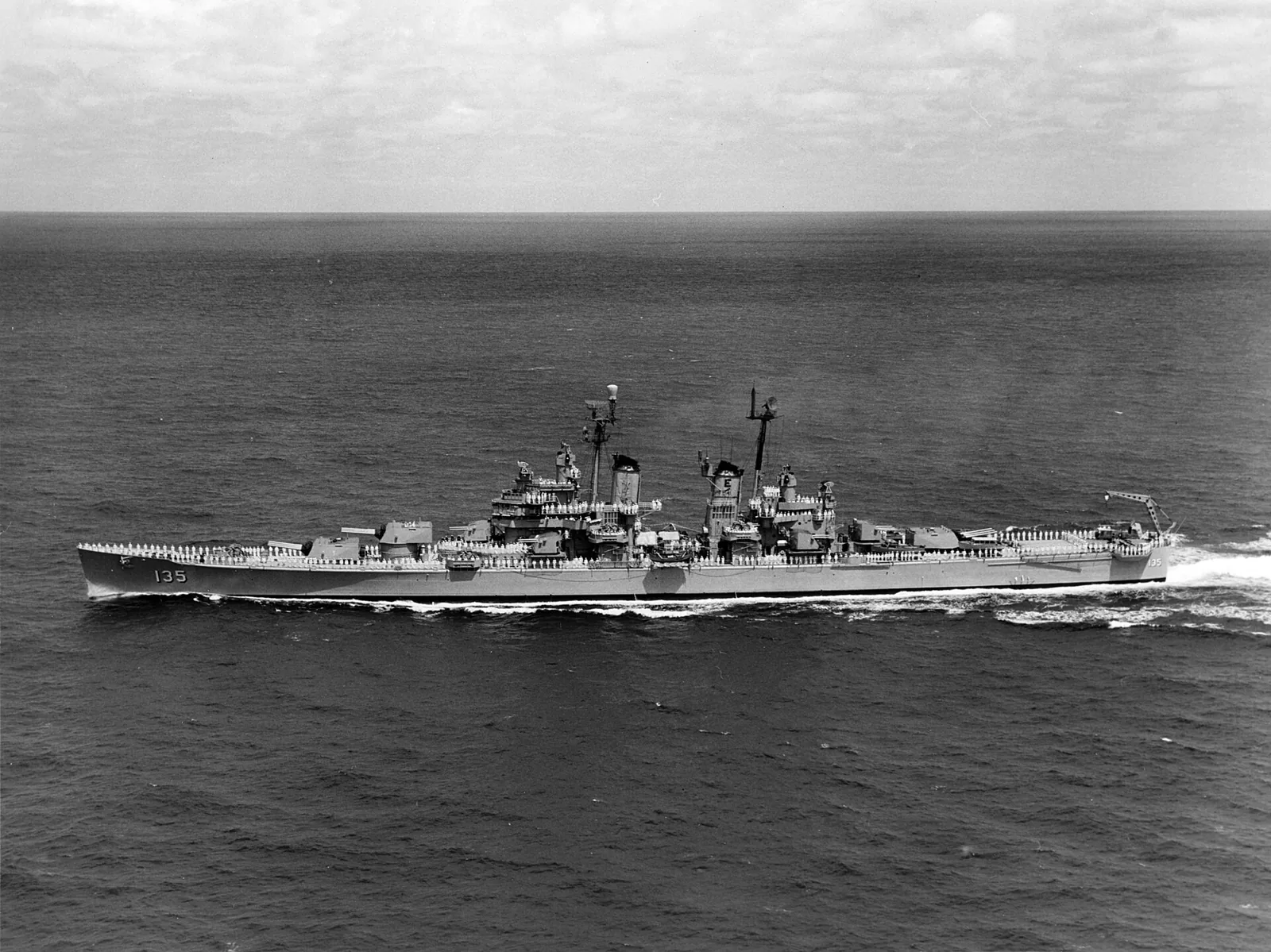 The U.S. Navy heavy cruiser USS Los Angeles (CA-135) underway on 27 April 1959. Original caption: "Officers and men of U.S.S. Los Angeles honor U.S. dead at Midway." The photo was presumably taken off the Midway Islands.