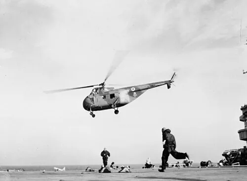 A Westland Whirlwind helicopter of the joint Royal Air Force/Army unit is leaving the Royal Navy commando carrier HMS Ocean (R68) with troops for Port Said during the Suez Crisis.