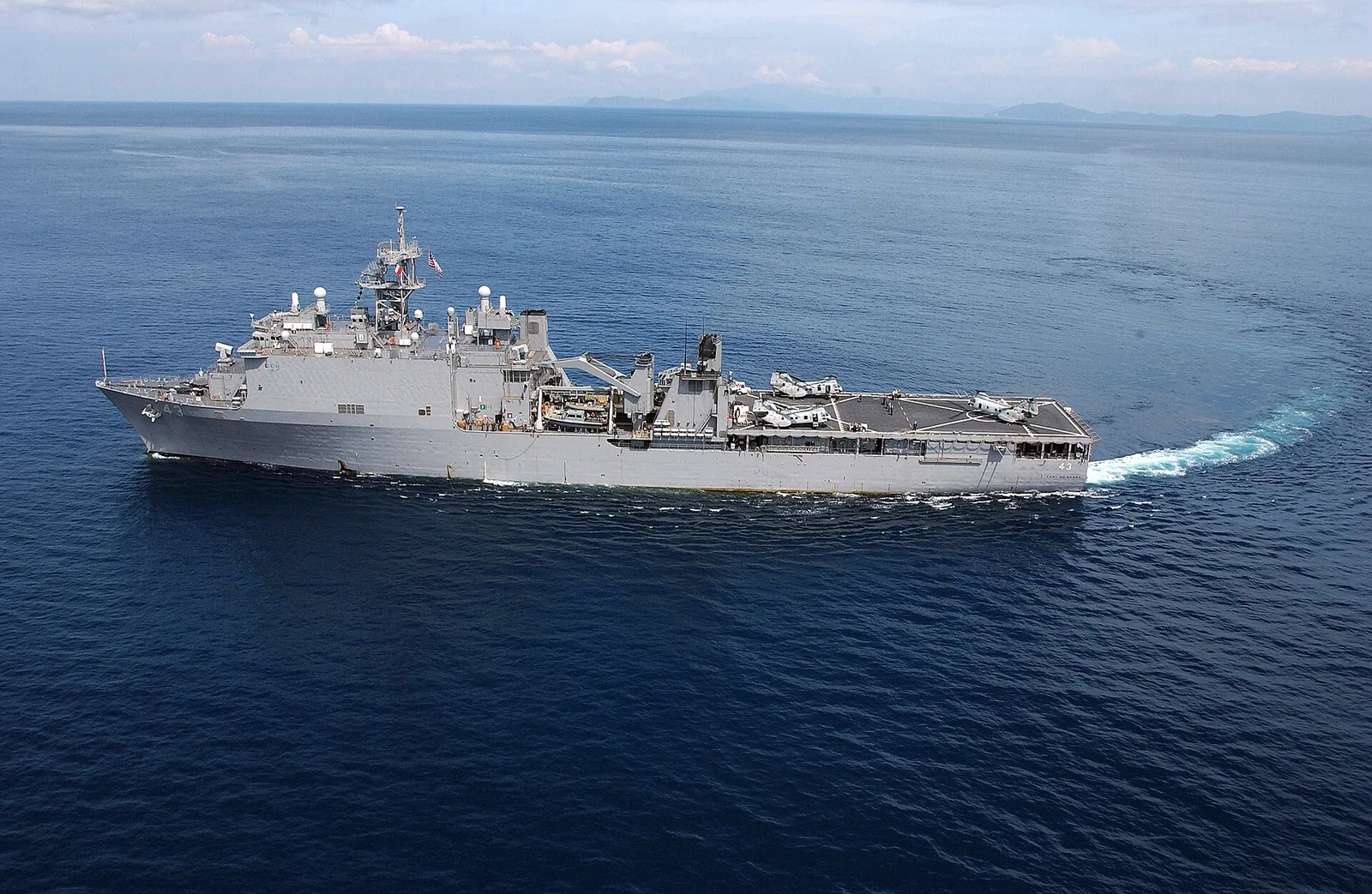 USS Fort McHenry (LSD 43) makes a wide turn prior to conducting helicopter operations off the coast of the island of Sumatra, Indonesia. Fort McHenry is providing platform support for helicopter operations deliver...