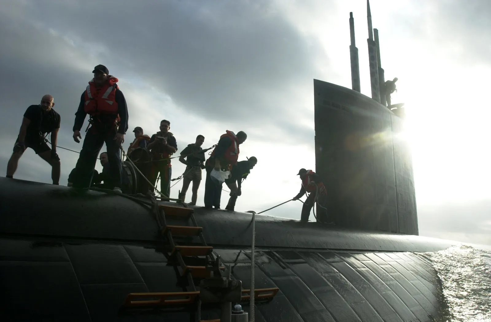 USS Greeneville (SSN 772) wait for USS Lake Champlain's Rigid Hull Inflatable Boat (RHIB) to maneuver into position so they can unload supplies and personnel. USS Greeneville is surfacing to receive...